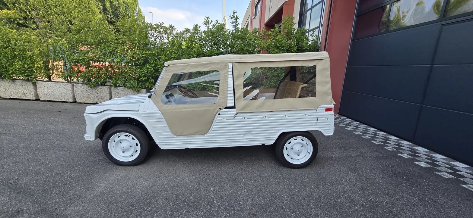 The white eStory electric classic car with sand canvas top, side view