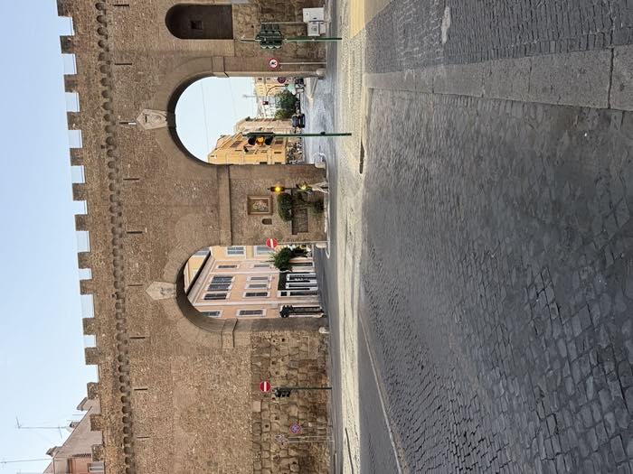 Le mura di Roma e la strada deserta poco dopo l'alba