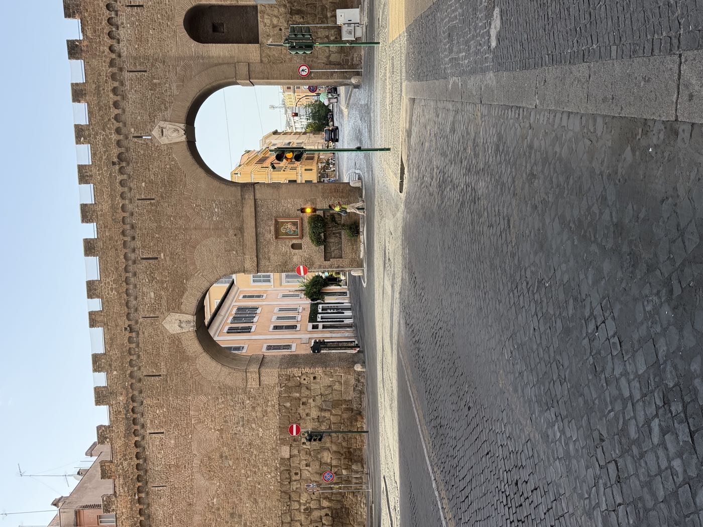 Le mura di Roma con la strada di sanpietrini ancora deserta, poco dopo l'alba